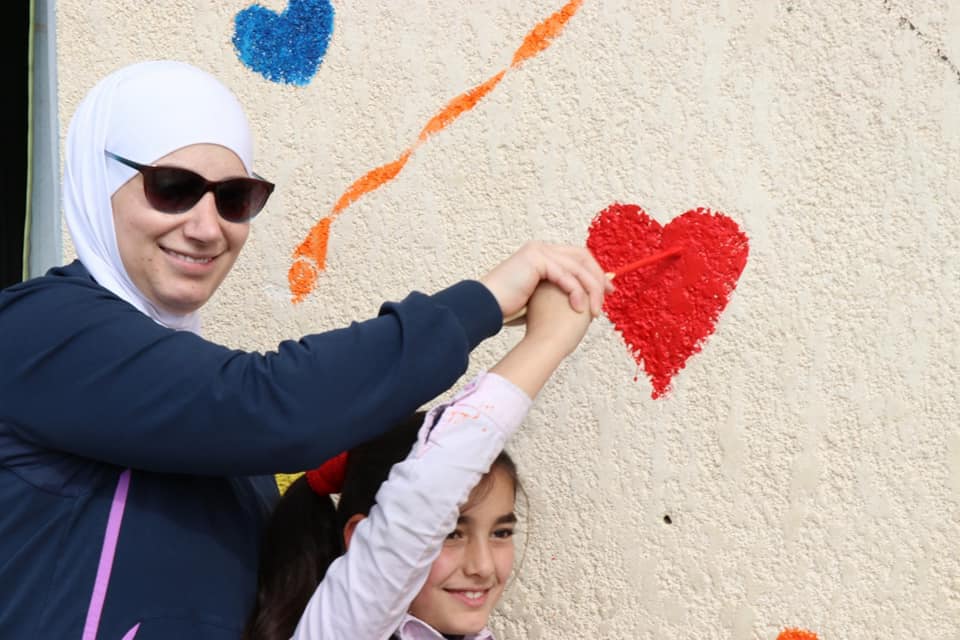 majd chourbaji drawing on a wall with student